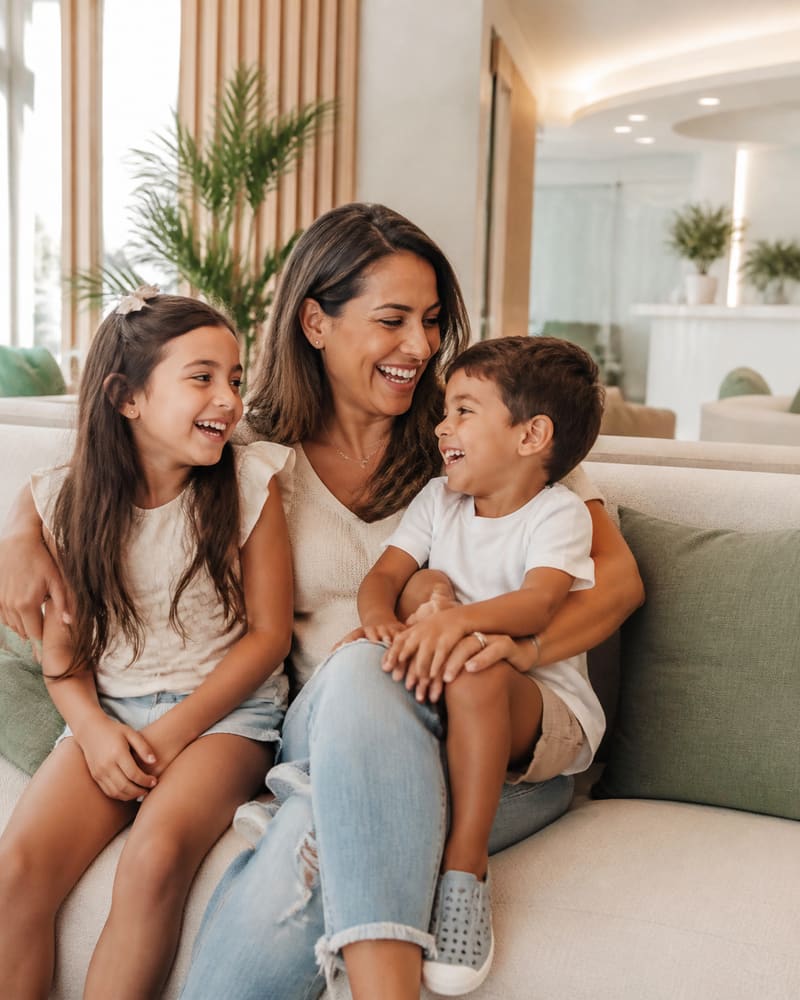 A mother with her two children laughing together in the waiting area
